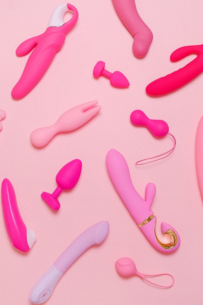 about-07 Explore a variety of pink adult toys including vibrators, silicone accessories, and more on a pastel background.